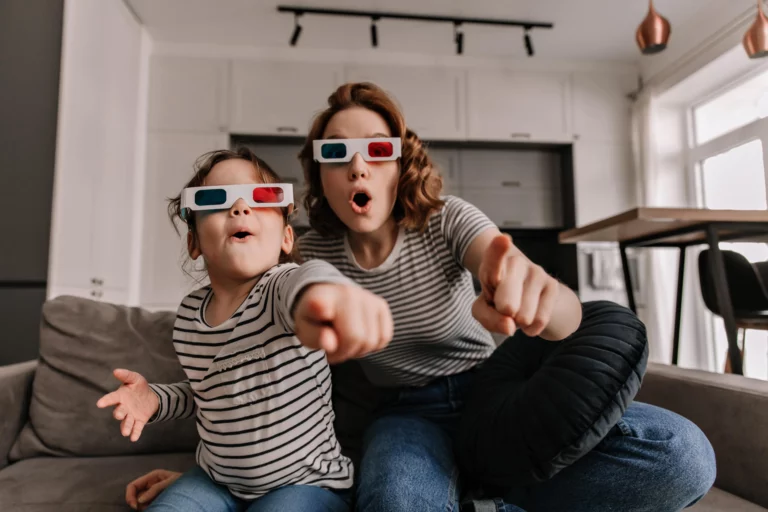 A mother and her daughter are enjoying their clean energy by watching a 3D movie.